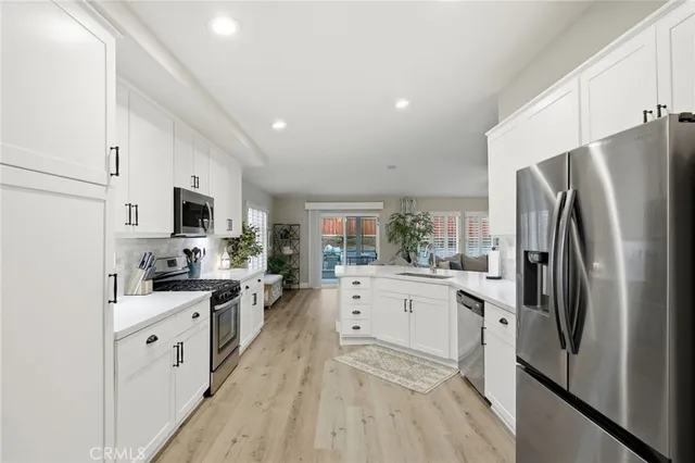 a kitchen with white cabinets and stainless steel appliances