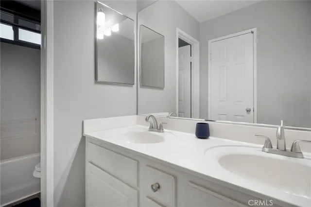 a bathroom with double sink and a mirror