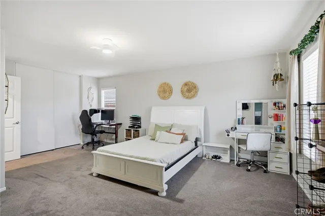 a spacious bedroom with a bed and a chair in it