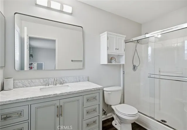 a bathroom with a granite countertop sink toilet and shower
