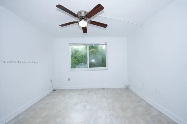 an empty room with chandelier fan