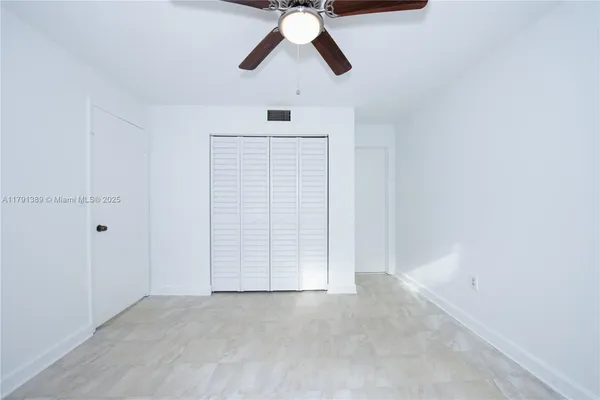 an empty room with chandelier fan