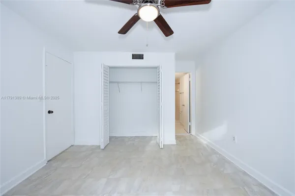 an empty room with chandelier fan