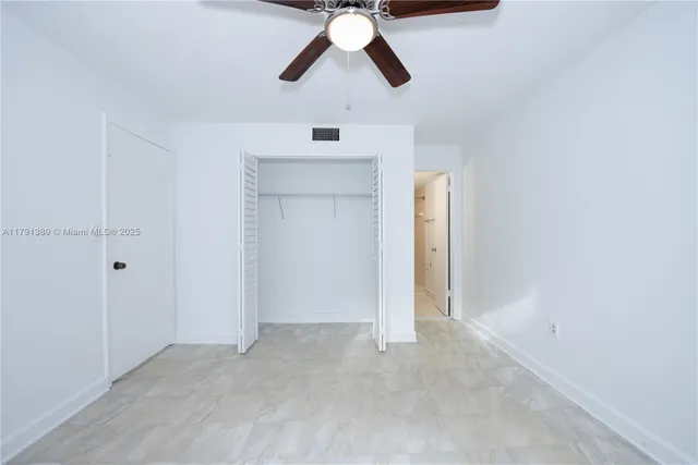 an empty room with chandelier fan