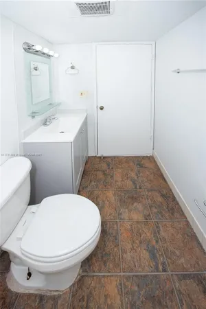 a bathroom with a sink a toilet and mirror