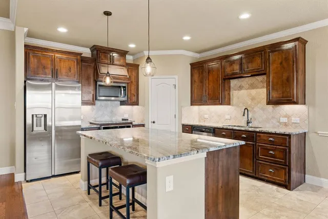 a kitchen with stainless steel appliances granite countertop a sink stove and refrigerator