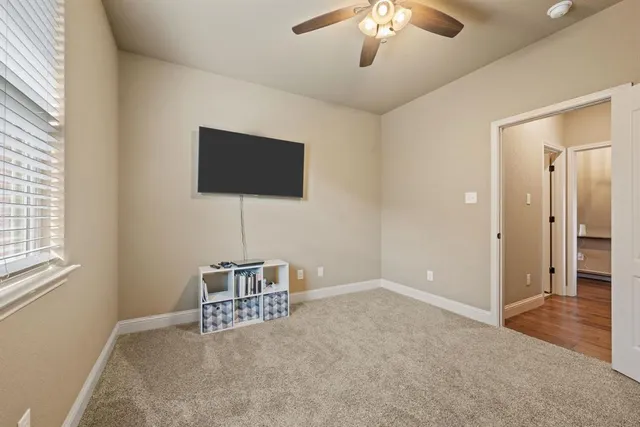 an empty room with windows and ceiling fan