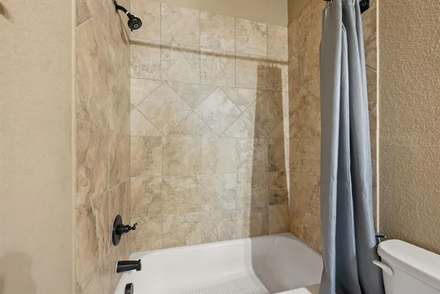 a bathroom with a shower and a toilet