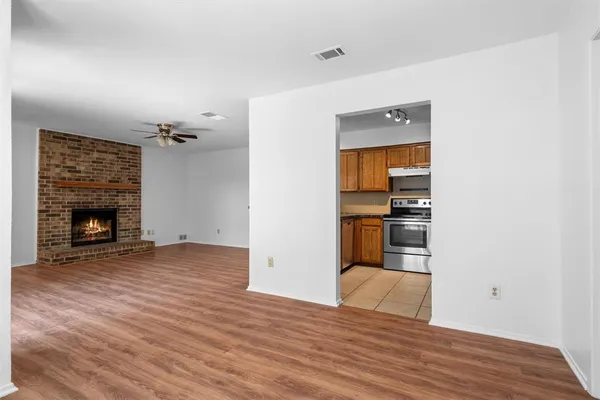 a view of empty room with wooden floor and fireplace