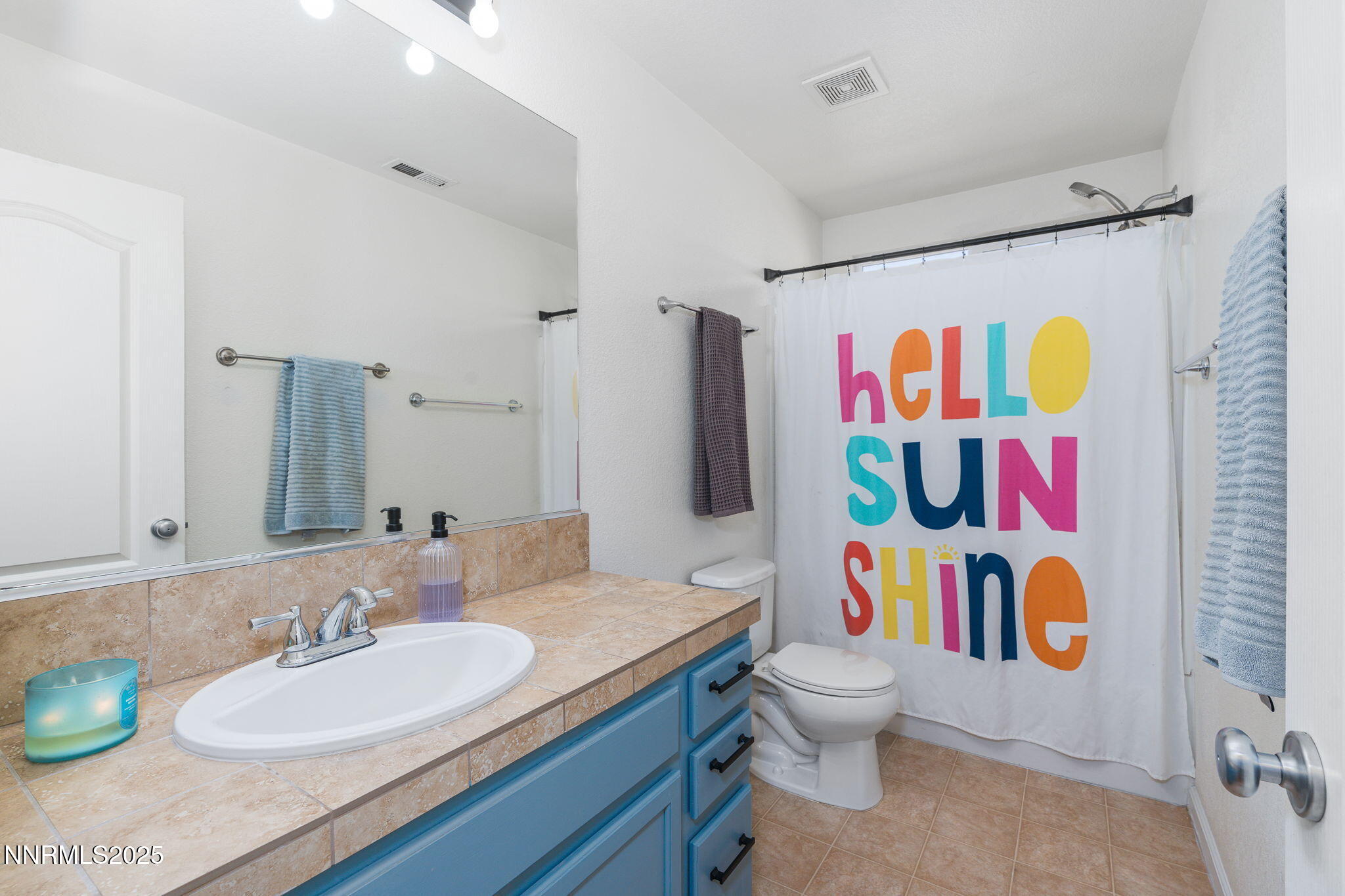 7220 Windswept Loop Sparks, NV 89436 - Photo 29 of 35 a bathroom with a sink a toilet and shower curtain