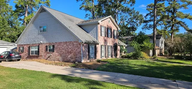 a front view of a house with garden and sitting area