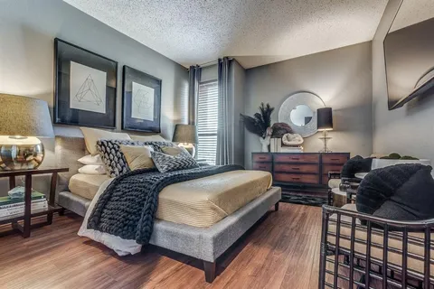 a bedroom with a large bed and a chandelier