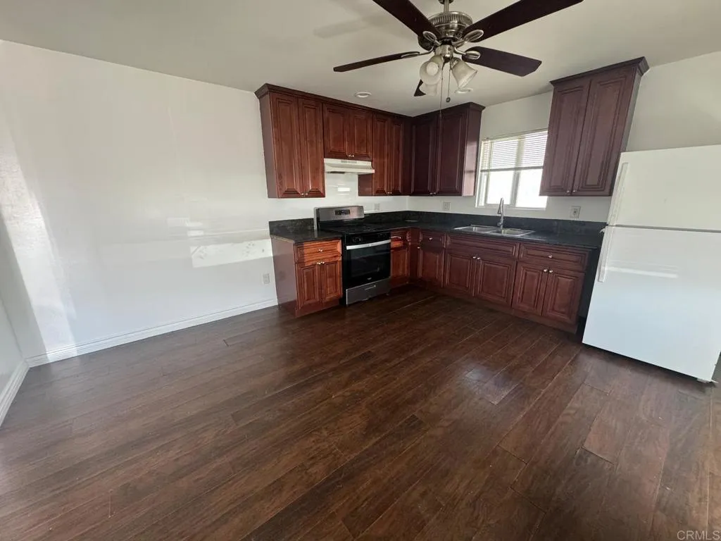 734 Grand Avenue Spring Valley, CA 91977 - Photo 12 of 33 a kitchen with granite countertop a stove cabinets and wooden floor