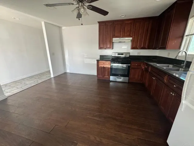 a kitchen with granite countertop a sink cabinets and stainless steel appliances
