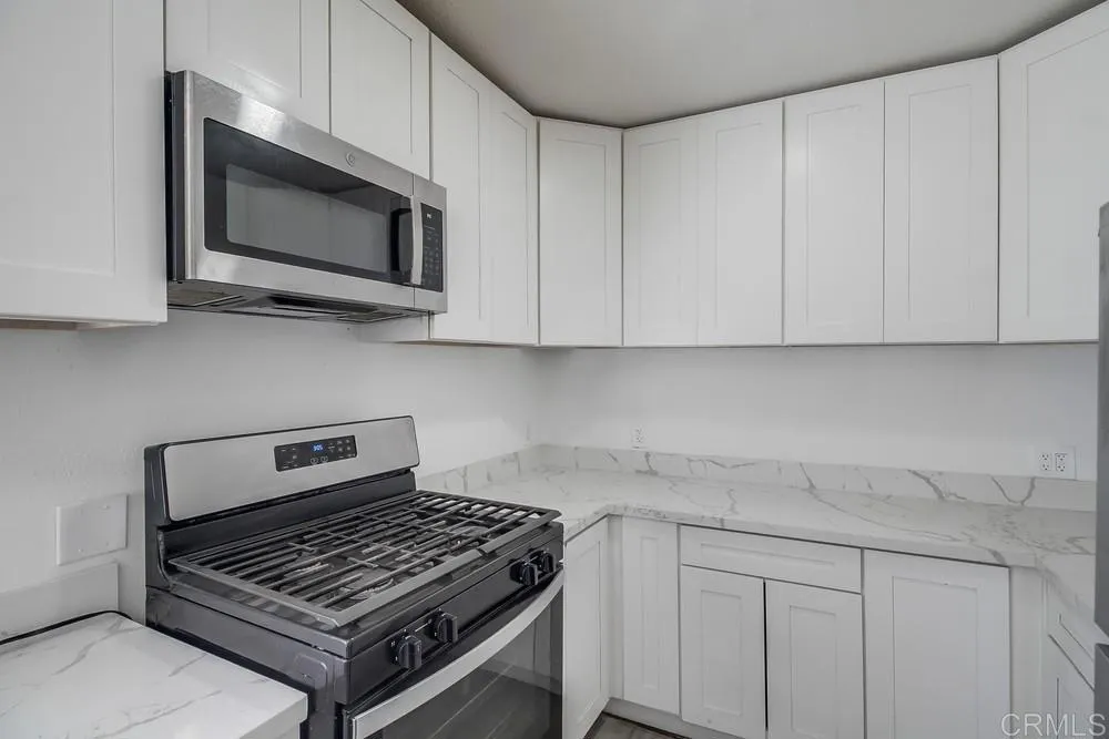 734 Grand Avenue Spring Valley, CA 91977 - Photo 19 of 33 a kitchen with white cabinets and a stove top oven