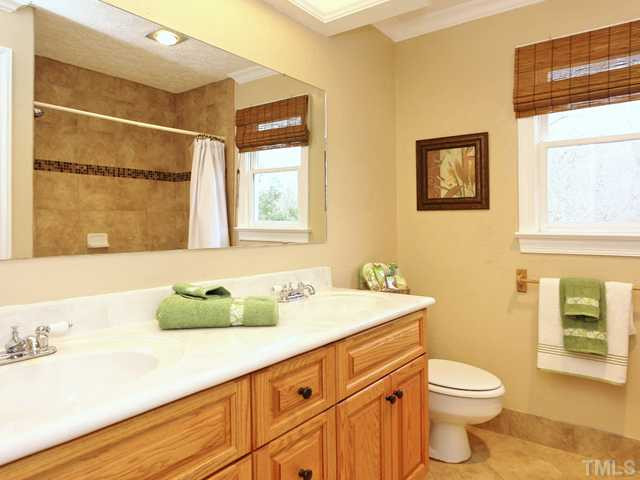 1605 Chatsworth Lane Raleigh, NC 27614 - Photo 18 of 25 Full hall bath with tile floor, tub/shower with tile surround and dual vanity sinks with oak cabinets and cultured marble countertops! Bathroom