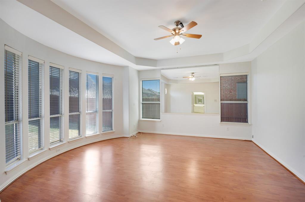 9618 Peach Tree Lane Rowlett, TX 75089 - Photo 13 of 40 a view of an empty room with wooden floor and a ceiling fan