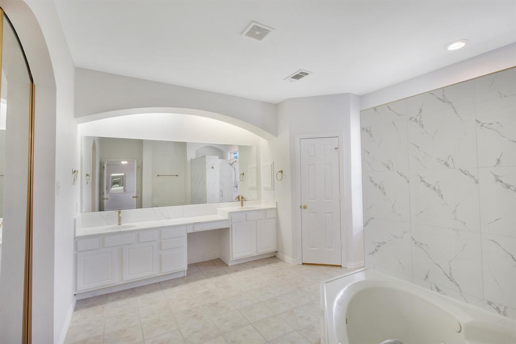 9618 Peach Tree Lane Rowlett, TX 75089 - Photo 14 of 40 a spacious bathroom with a bathtub shower sink and mirror