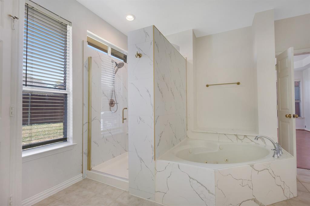 9618 Peach Tree Lane Rowlett, TX 75089 - Photo 15 of 40 a bathroom with a bathtub and a shower