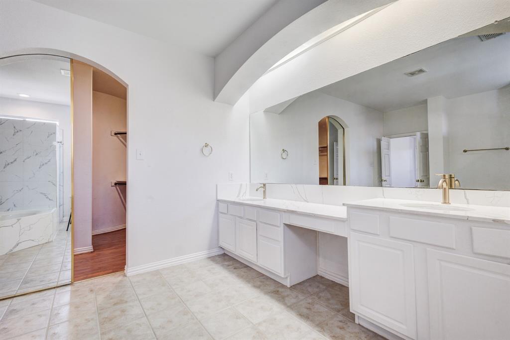 9618 Peach Tree Lane Rowlett, TX 75089 - Photo 16 of 40 a spacious bathroom with a double vanity sink and a mirror