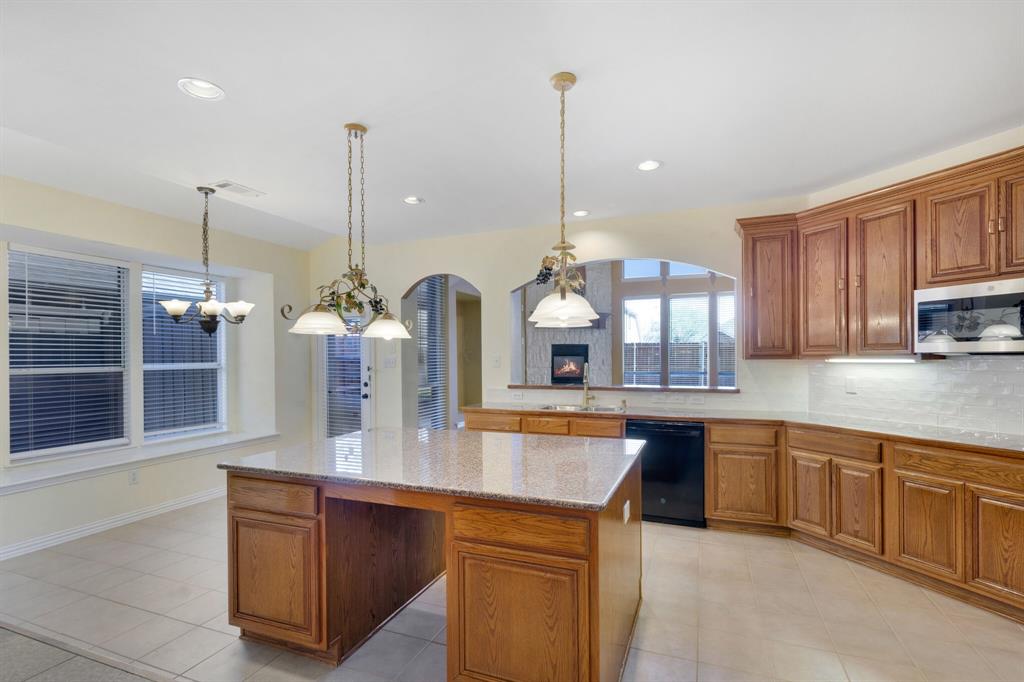 9618 Peach Tree Lane Rowlett, TX 75089 - Photo 23 of 40 a kitchen with stainless steel appliances granite countertop a sink a stove and a wooden floors