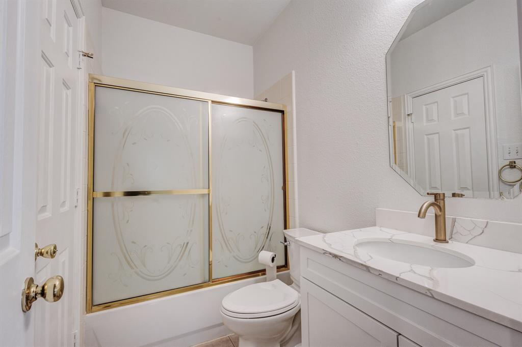 9618 Peach Tree Lane Rowlett, TX 75089 - Photo 10 of 40 a bathroom with a granite countertop sink toilet and shower