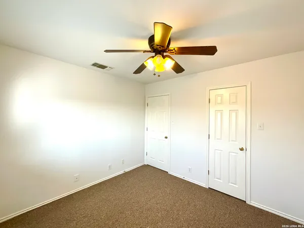 an empty room with a window and a ceiling fan