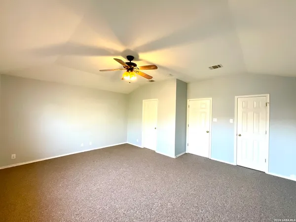 an empty room with a ceiling fan and carpet