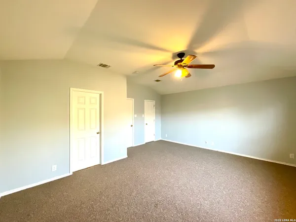 an empty room with a window and a ceiling fan