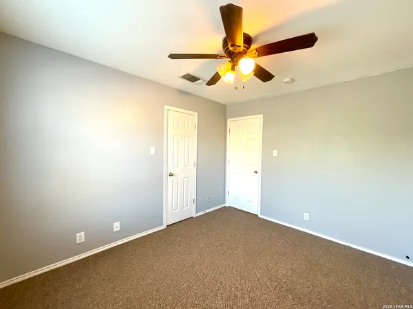 an empty room with a window and a chandelier