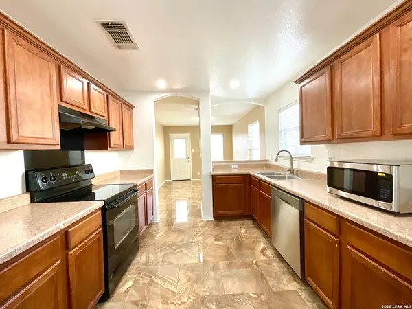 a large kitchen with stainless steel appliances granite countertop a stove sink and cabinets