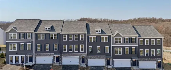 a front view of a residential apartment building with a yard and mountain view