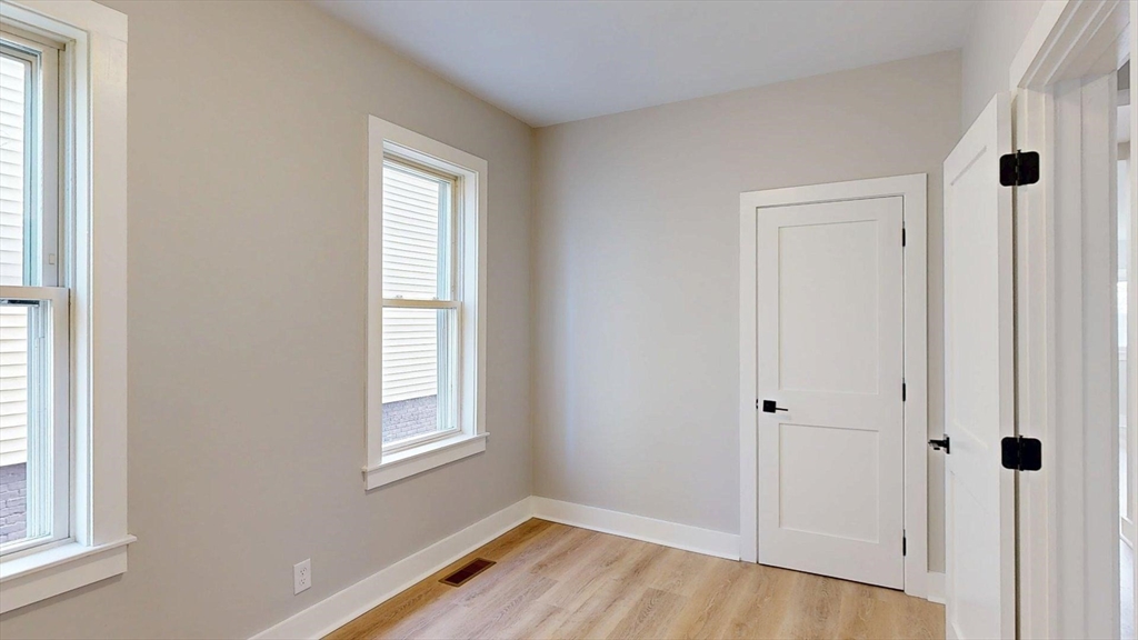 273 Maverick Street, Unit 7 Boston, MA 02128 - Photo 13 of 26 a view of an empty room with wooden floor and a window