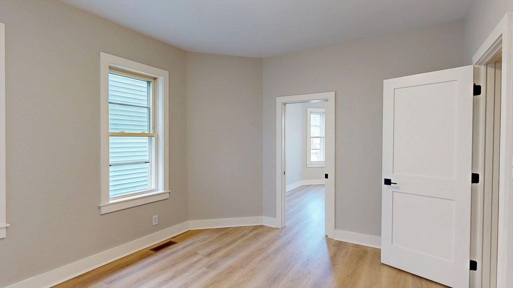 273 Maverick Street, Unit 7 Boston, MA 02128 - Photo 16 of 26 an empty room with wooden floor and windows