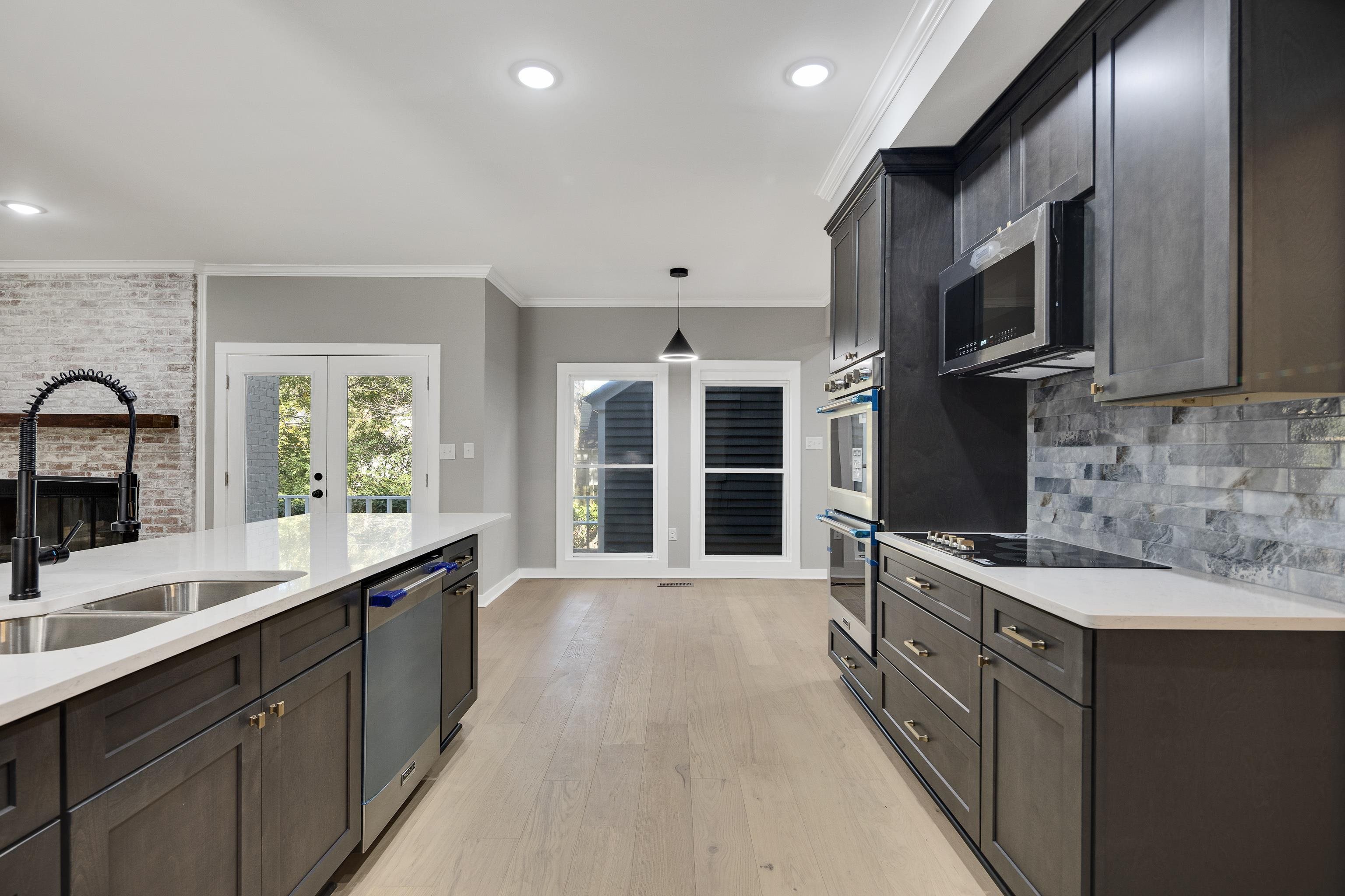 6380 Kirby Ridge Cove Memphis, TN 38119 - Photo 11 of 40 Kitchen with tasteful backsplash, french doors, light stone counters, pendant lighting, and light wood-type flooring