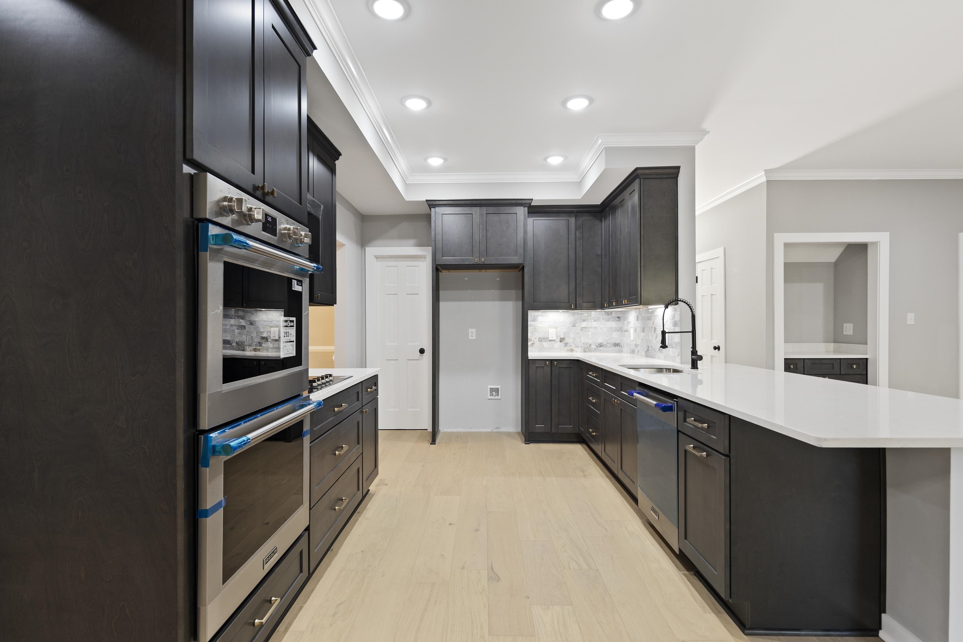 6380 Kirby Ridge Cove Memphis, TN 38119 - Photo 13 of 40 Kitchen with stainless steel appliances, ornamental molding, backsplash, light wood finished floors, and recessed lighting