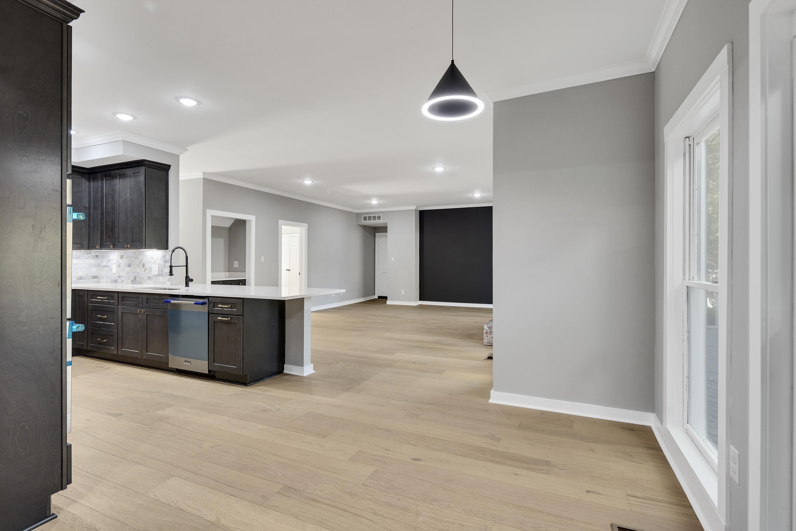 6380 Kirby Ridge Cove Memphis, TN 38119 - Photo 38 of 40 Kitchen featuring crown molding, pendant lighting, a peninsula, light wood-style flooring, and open floor plan