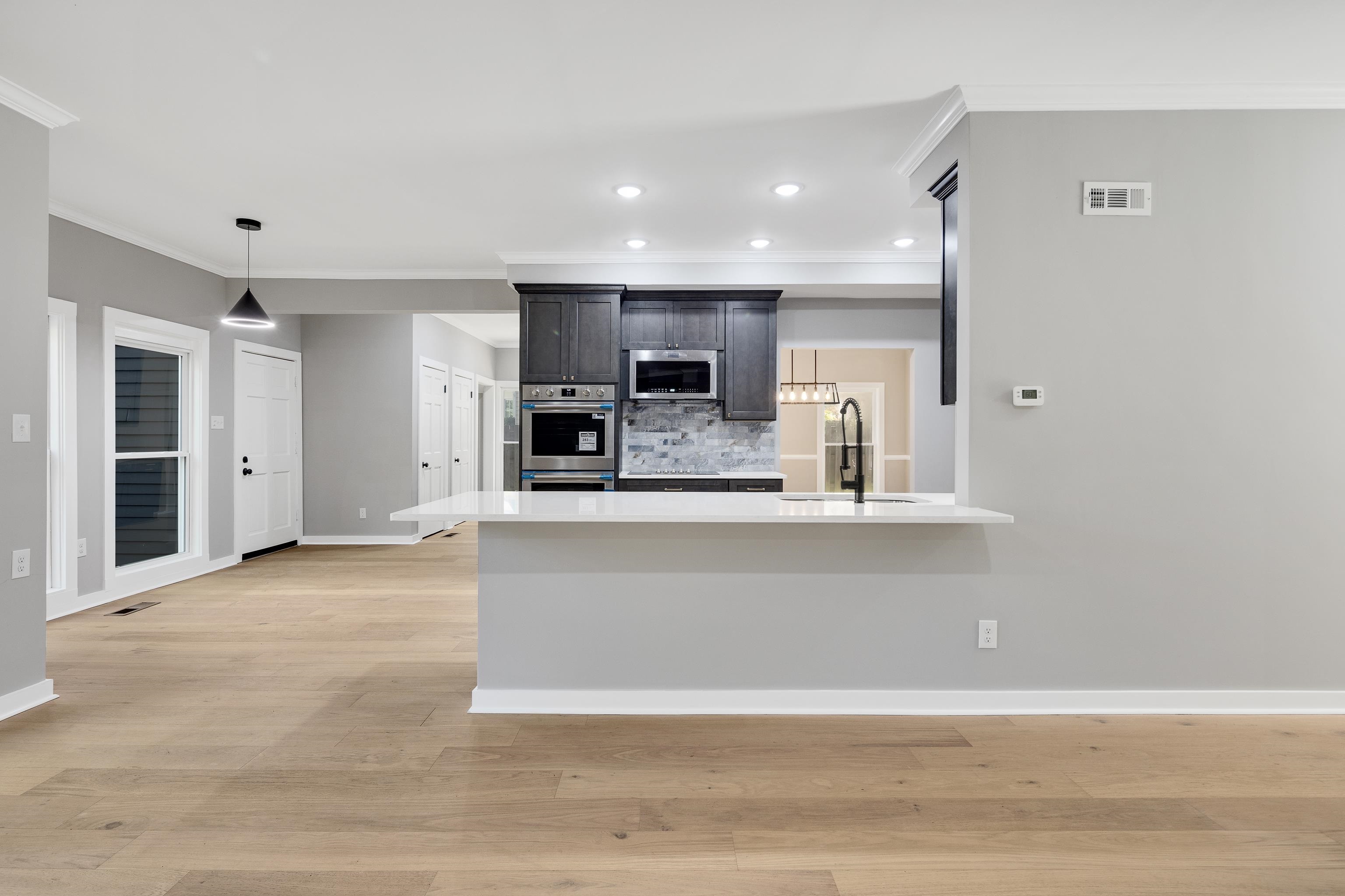 6380 Kirby Ridge Cove Memphis, TN 38119 - Photo 16 of 40 Kitchen with pendant lighting, recessed lighting, crown molding, tasteful backsplash, and light stone countertops