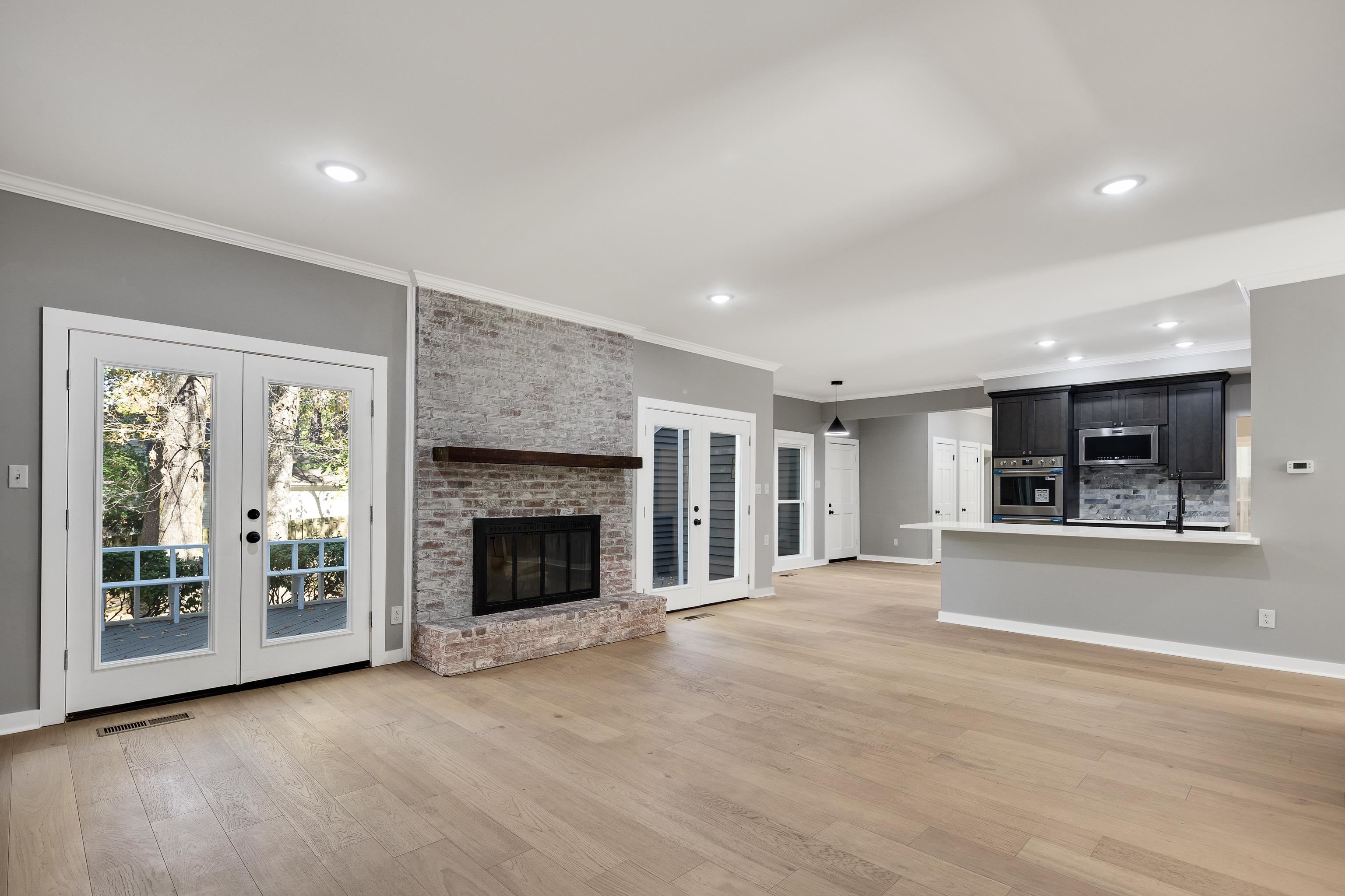 6380 Kirby Ridge Cove Memphis, TN 38119 - Photo 19 of 40 Unfurnished living room featuring french doors, a fireplace, light wood-style floors, crown molding, and recessed lighting