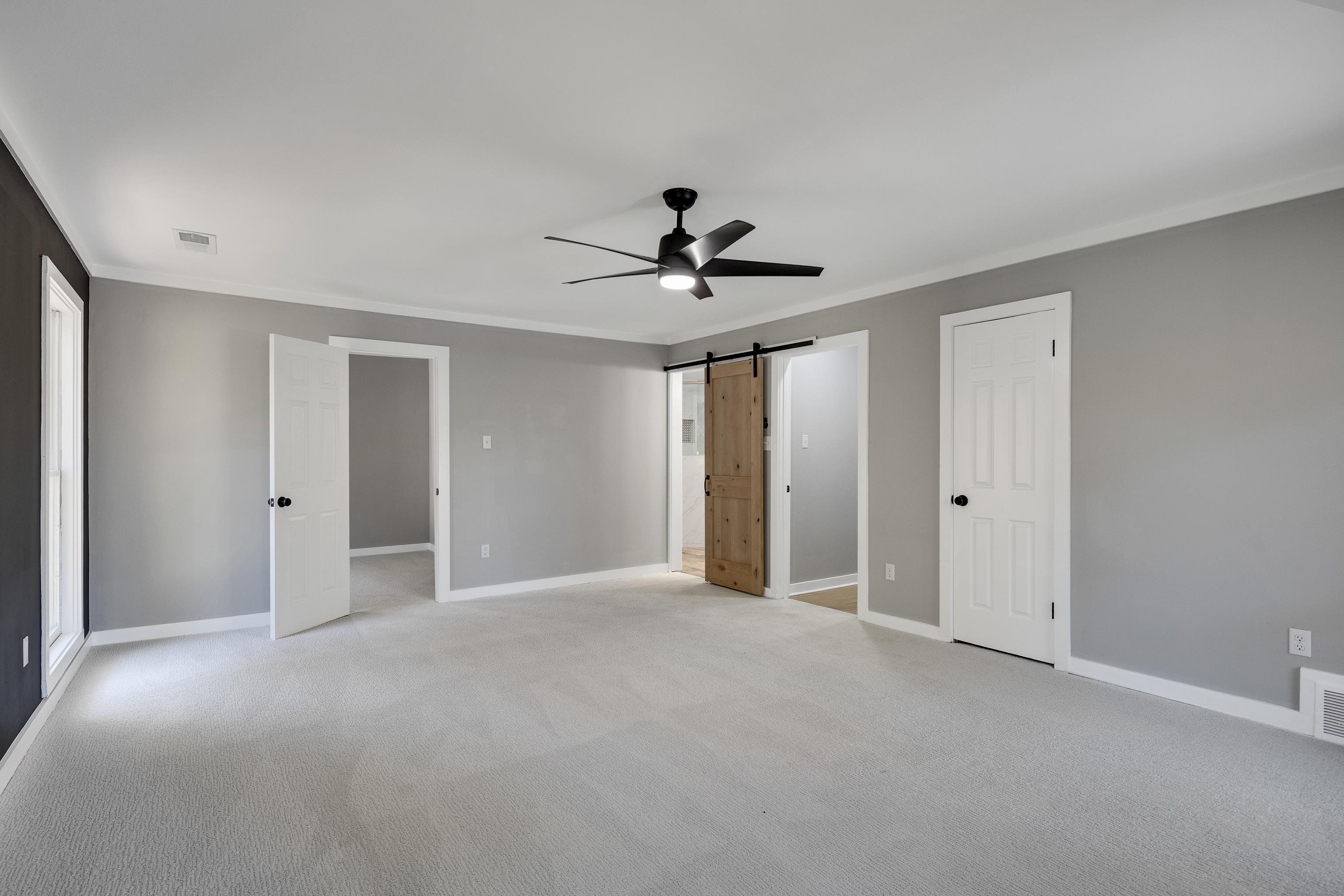 6380 Kirby Ridge Cove Memphis, TN 38119 - Photo 30 of 40 Unfurnished bedroom featuring a barn door, crown molding, light carpet, a ceiling fan, and ensuite bath