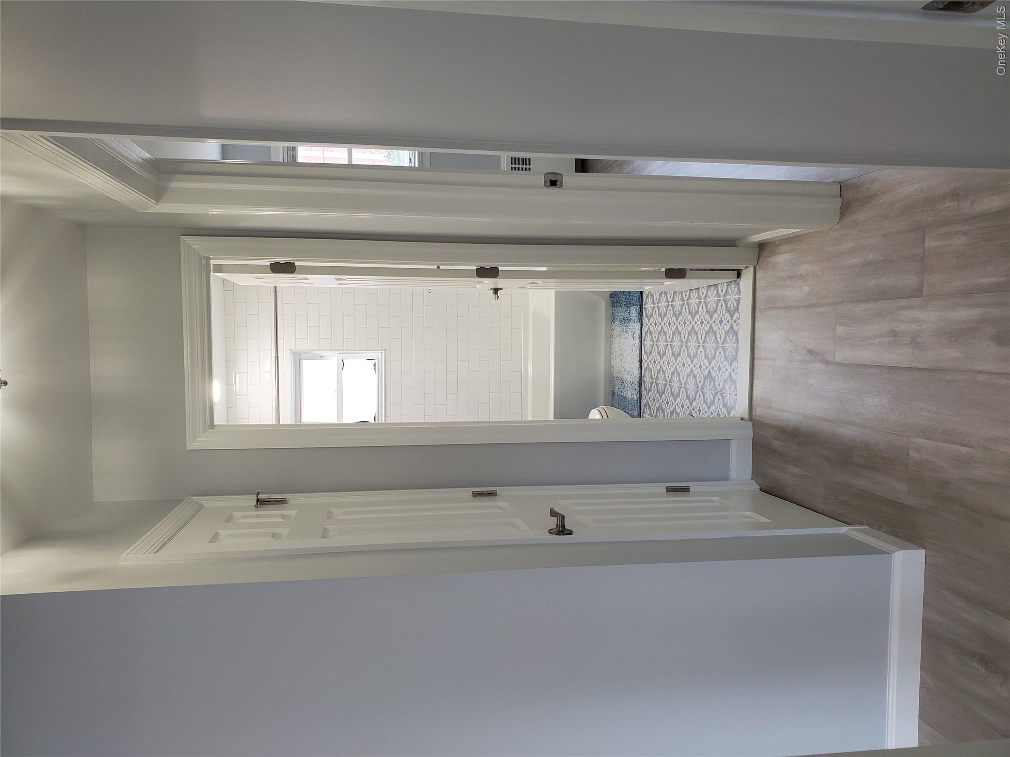 1879 Crompond Road, Unit A21 Peekskill, NY 10566 - Photo 14 of 20 a view of an empty room with wooden floor and a bathroom