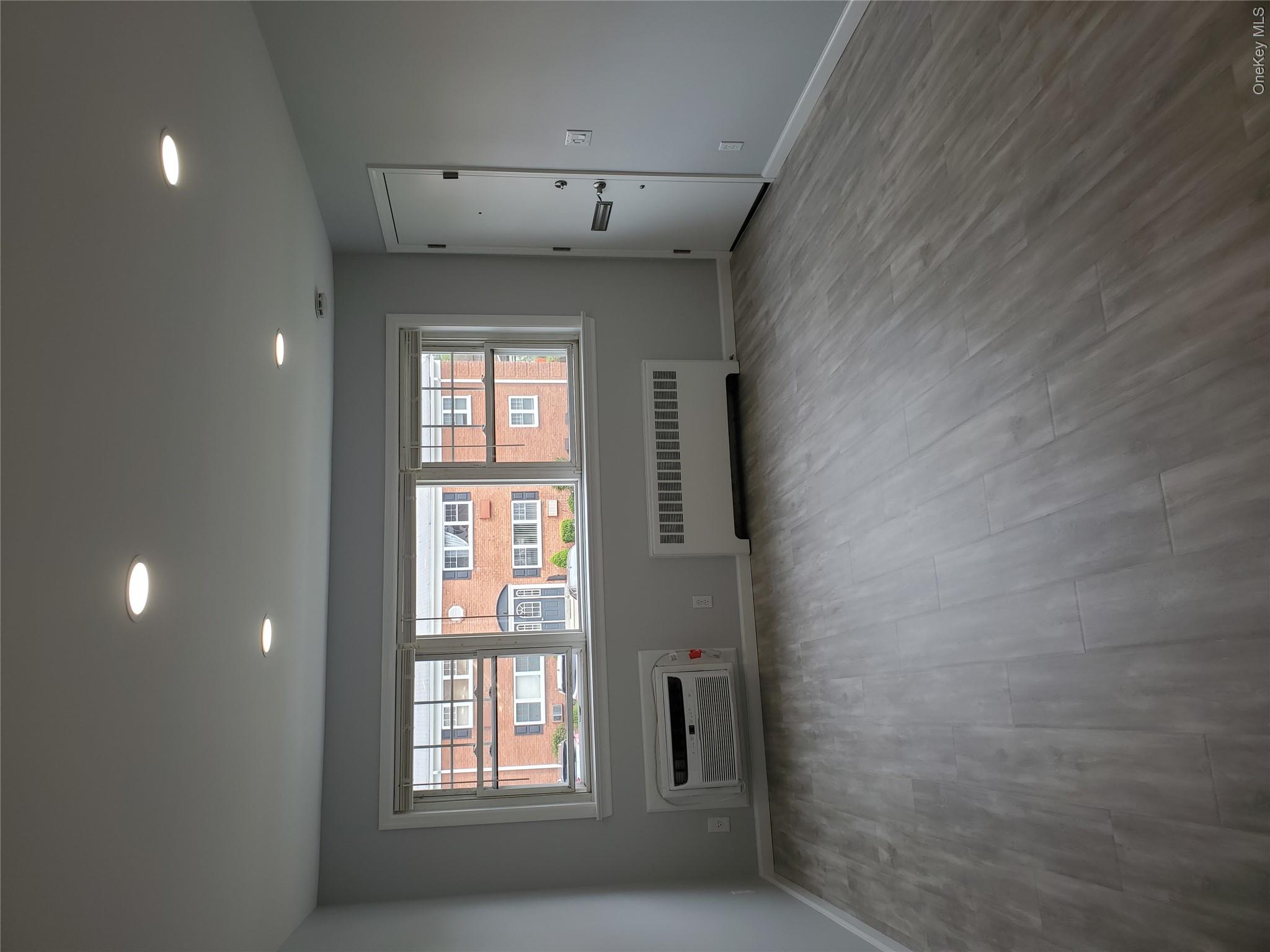 1879 Crompond Road, Unit A21 Peekskill, NY 10566 - Photo 2 of 20 an empty room with wooden floor and windows