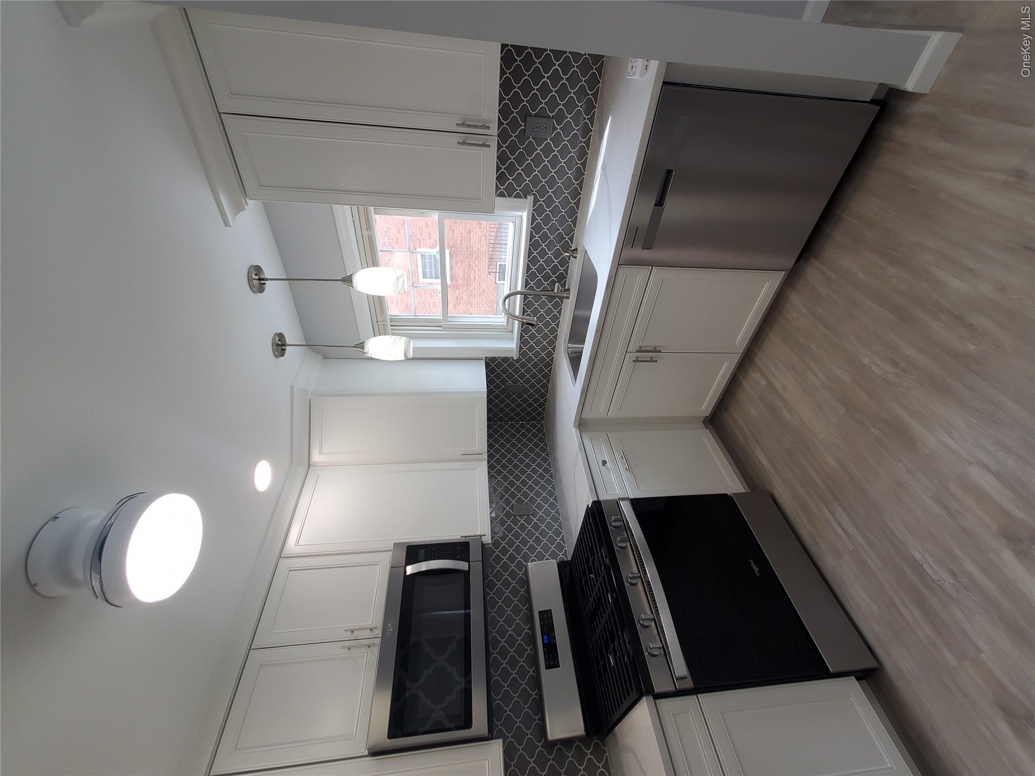 1879 Crompond Road, Unit A21 Peekskill, NY 10566 - Photo 8 of 20 a kitchen with a stove a sink and a microwave