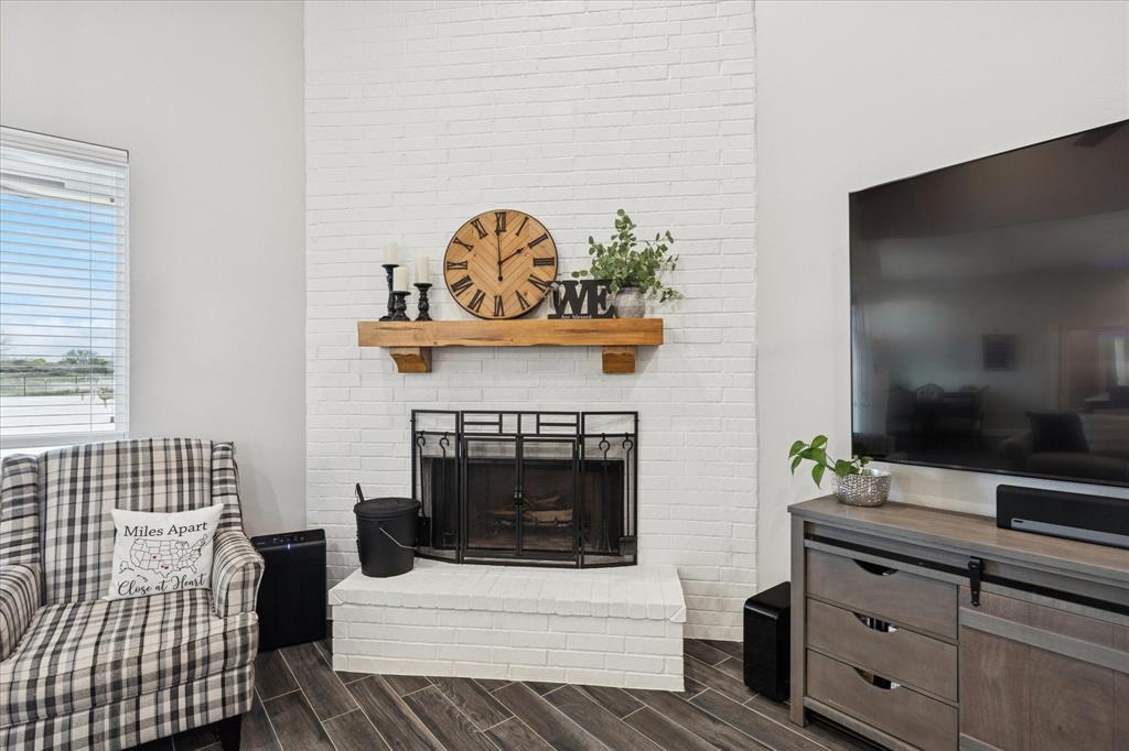 112 Friendship Way Boyd, TX 76023 - Photo 8 of 29 Floor-to-ceiling brick fireplace with a substantial wood mantel