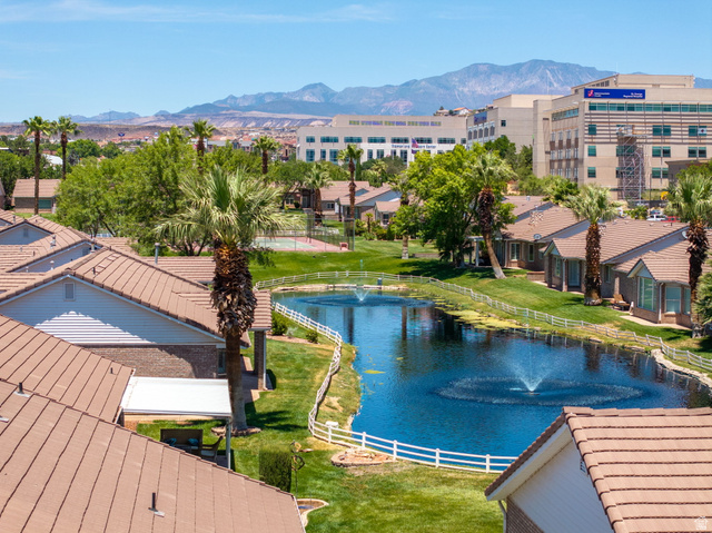 805 South River Road, Unit 70 St. George, UT 84790 - Photo 33 of 38 Community pond with dual water features, surrounded by manicured green spaces and palm trees