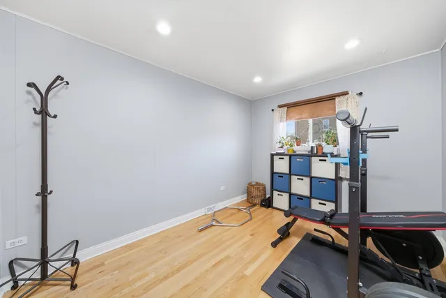 a room with gym equipment and wooden floor