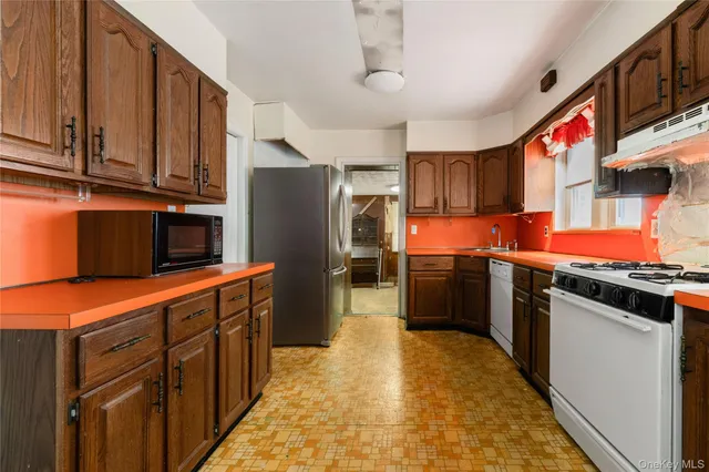 a kitchen with stainless steel appliances granite countertop a refrigerator and a stove top oven