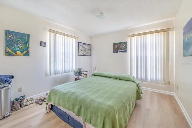 a bedroom with a bed and wooden floor