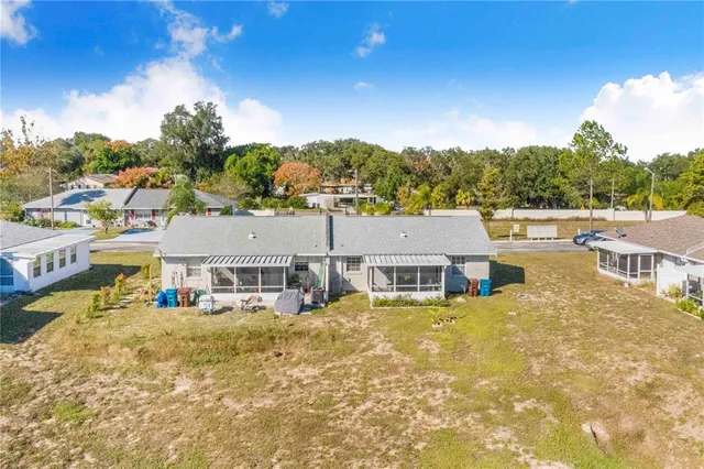 a view of a house with a big yard and large trees