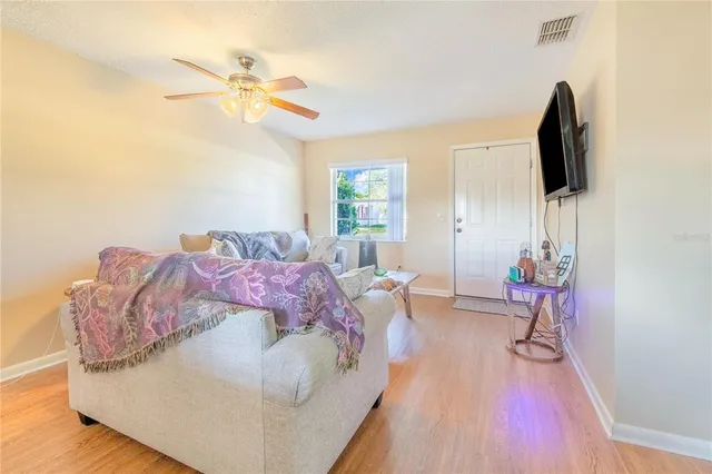 a spacious bedroom with a bed and a flat tv screen on dresser